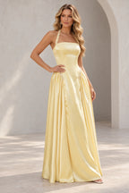 Light yellow A line prom dress with pearl-like halter strap details, a straight neckline, elongated bodice, and gathered side skirt panels.