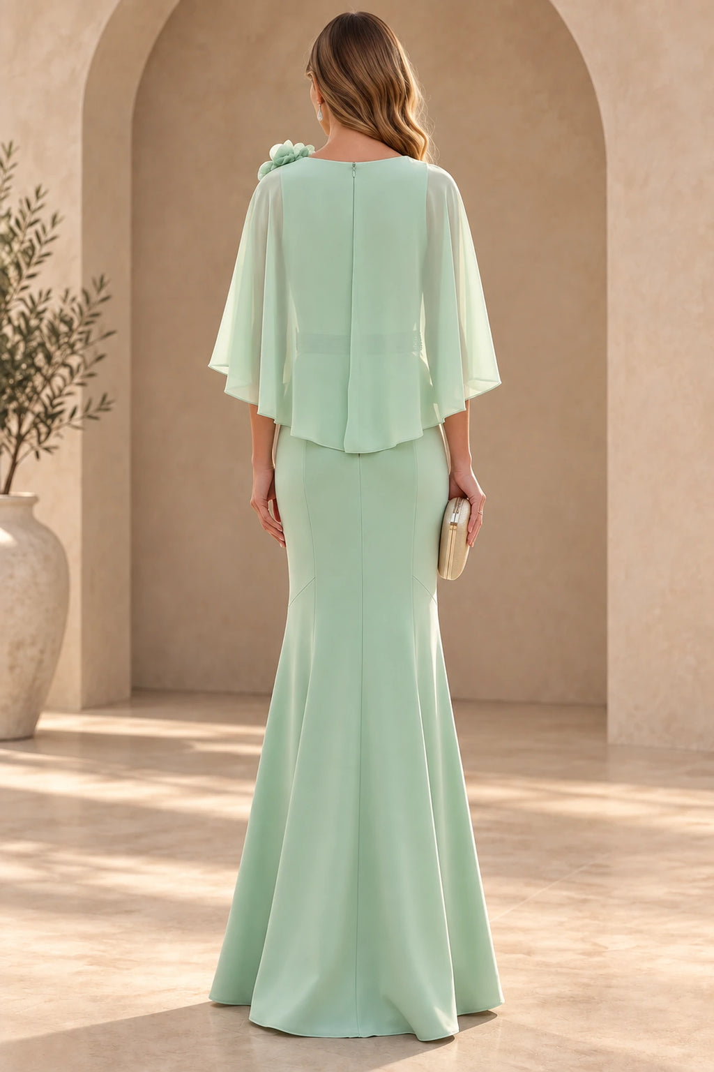 Back view of mint green floor-length mother of the bride dress with cape overlay center zipper and flared mermaid skirt