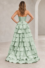 Back view of a mint green prom dress with matching corset lacing, a waist bow with long ties, and cascading ruffle tiers.