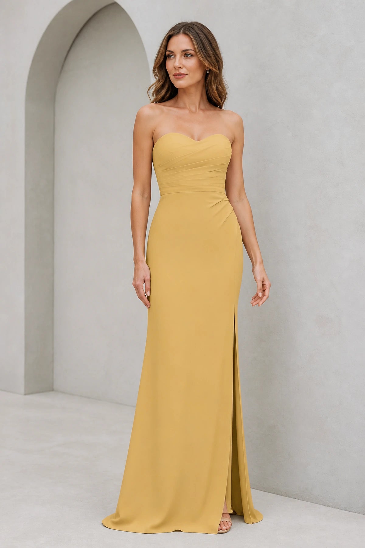 Mustard yellow bridesmaid dress with sweetheart neckline, strapless ruched bodice, side slit and floor-length sheath silhouette, front and back view