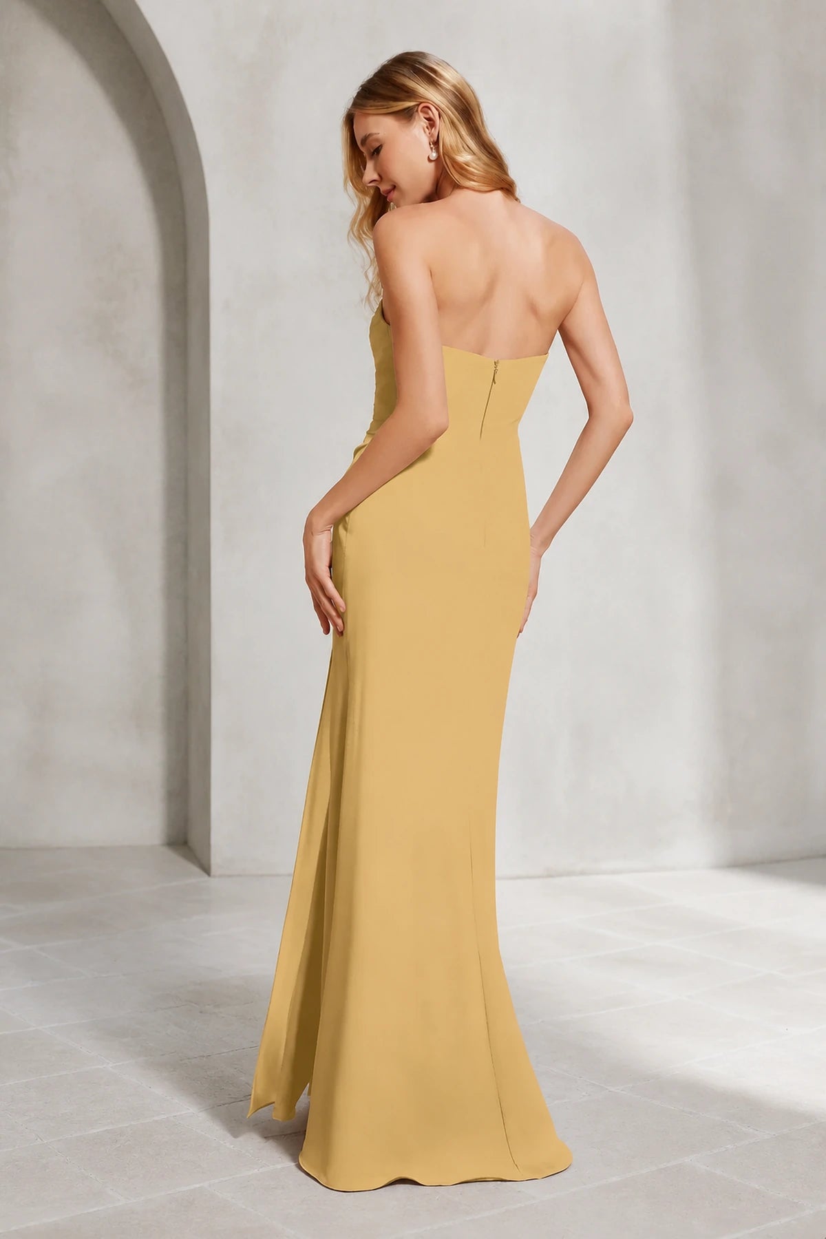 Mustard yellow bridesmaid dress with sweetheart neckline, strapless ruched bodice, side slit and floor-length sheath silhouette, front and back view