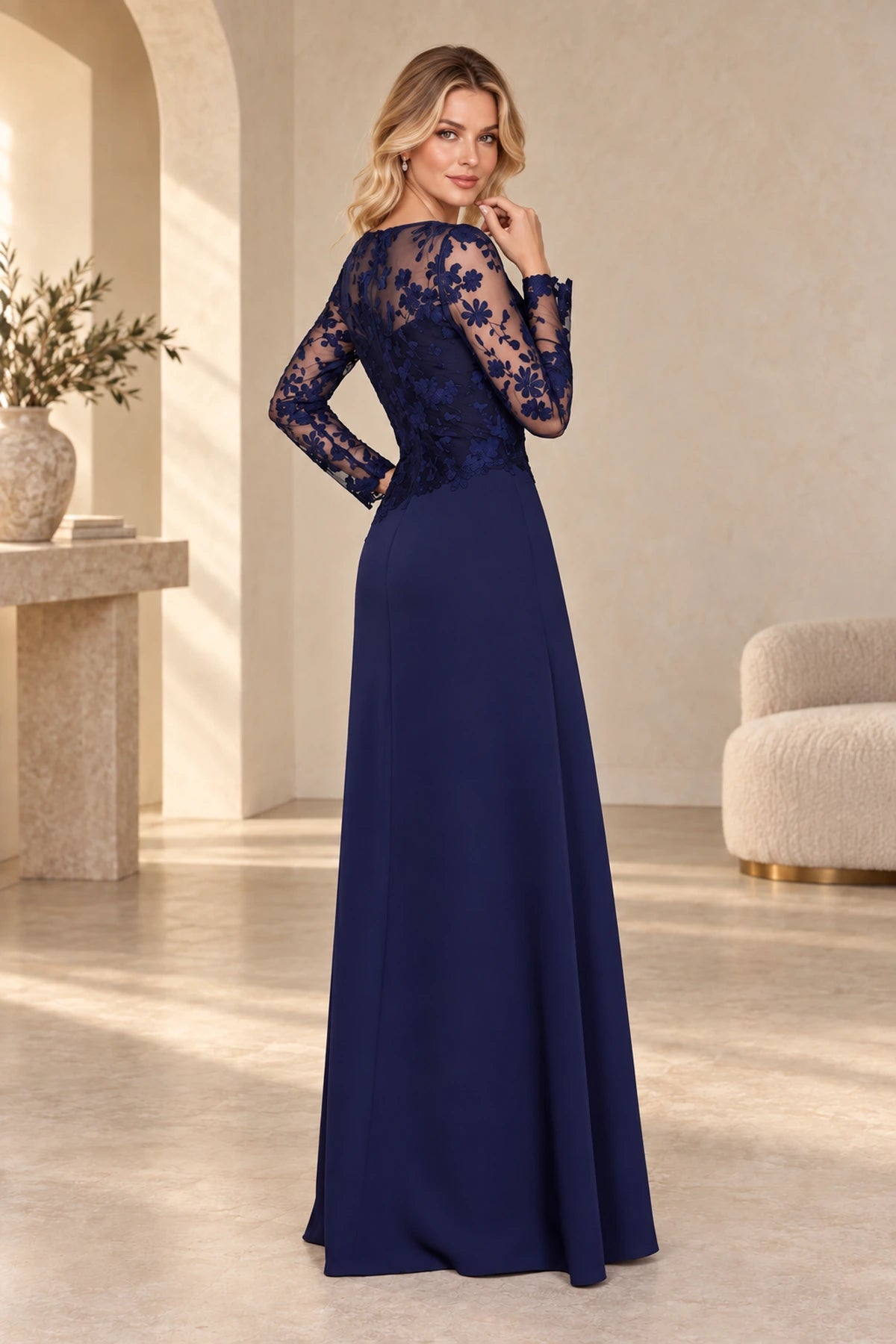 Back view of navy Mother of the Bride Dress with sheer floral lace back, long sleeves and flowing floor-length skirt
