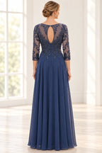 Back view of navy mother of the bride dress with sheer embroidered back, keyhole opening, three-quarter sleeves, and flowing floor-length skirt