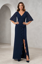 Front and back view of a navy mother of the bride dress with V-neck, sheer flutter sleeves, ruched bodice, cascading ruffle front slit, V-back, and floor-length silhouette