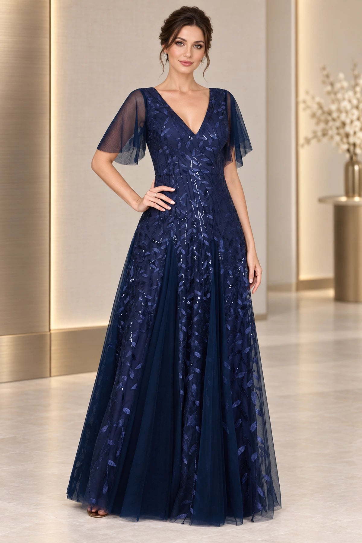 Navy mother of the bride dress with V neckline flutter sleeves sequined leaf overlay and floor length A-line skirt