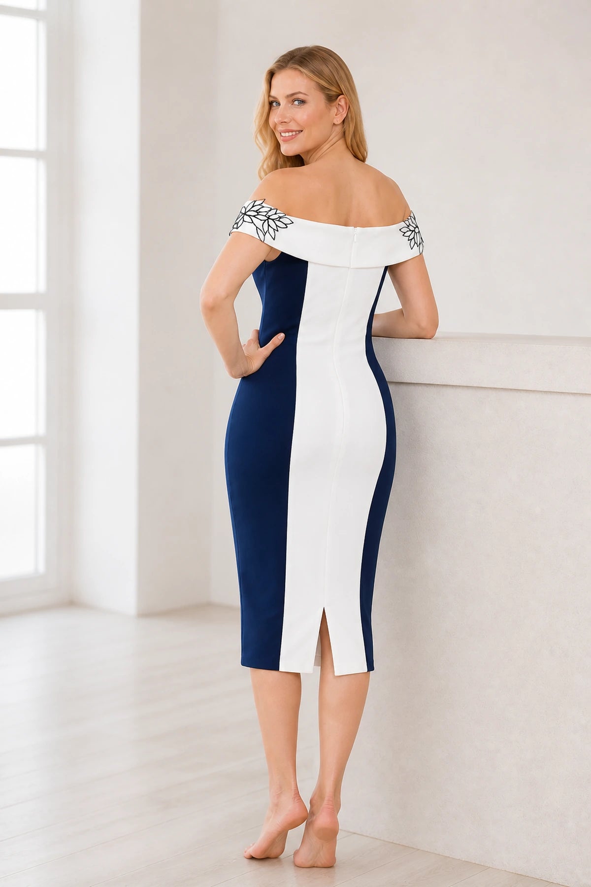 Navy and white Mother of the Bride dress with off-shoulder neckline, floral shoulder details, fitted sheath silhouette and midi length, front and back view