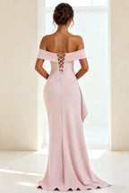 Back view of blush pink off-the-shoulder prom dress featuring a lace-up corset closure, fitted sheath silhouette and floor-length skirt.