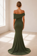 Back view of olive green wedding guest dress with off-shoulder drape, closed back and sweeping floor-length hem