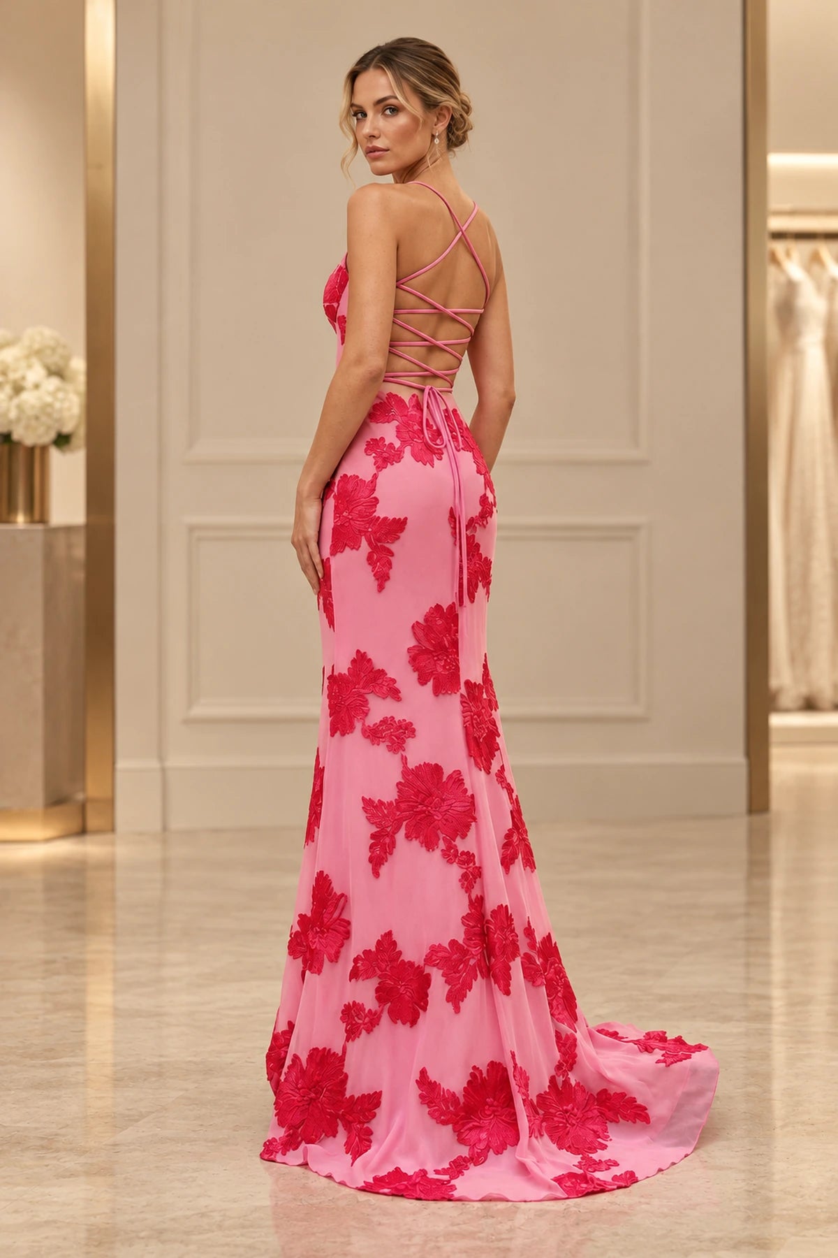 Back view of pink floral embroidered mermaid prom dress featuring an open back, crisscross lace-up straps, tie closure, and elegant sweep train.