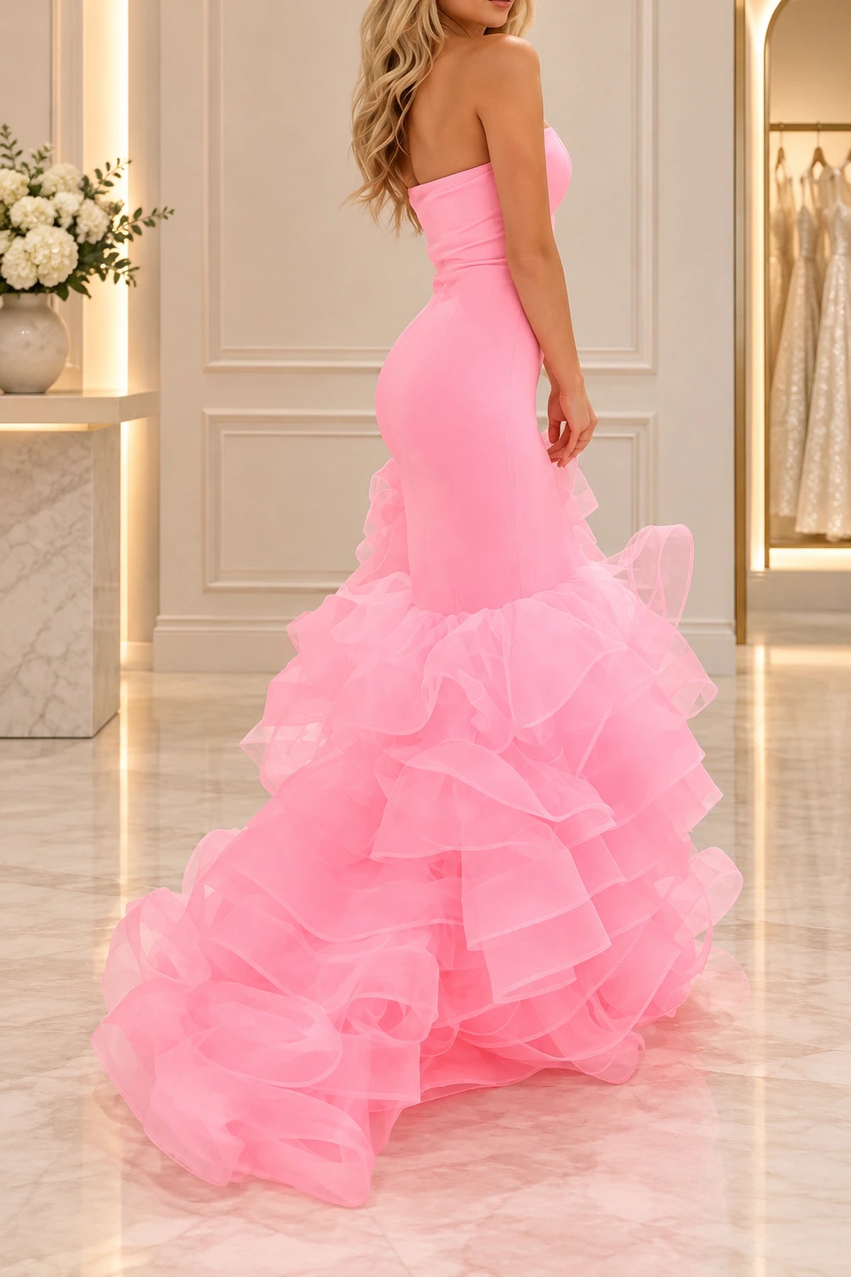 Back view of pink strapless mermaid prom dress with a fitted smooth bodice, contour seams, and voluminous cascading tiered tulle ruffles by Graceprom.