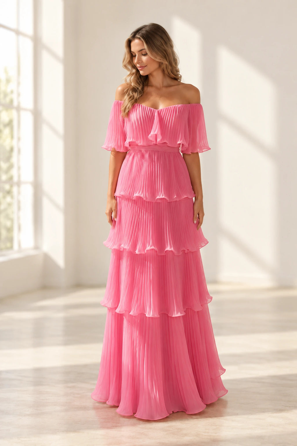 Pink pleated chiffon A-line wedding guest dress with off shoulder neckline, flutter sleeves, tiered ruffle skirt and floor length hem by Graceprom