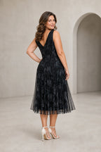 Plus size black tea-length mother dress with V-neck sleeveless bodice and pleated floral overlay