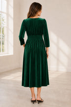 Plus size emerald green velvet mother of the bride dress with V neckline long sleeves and pleated tea length skirt