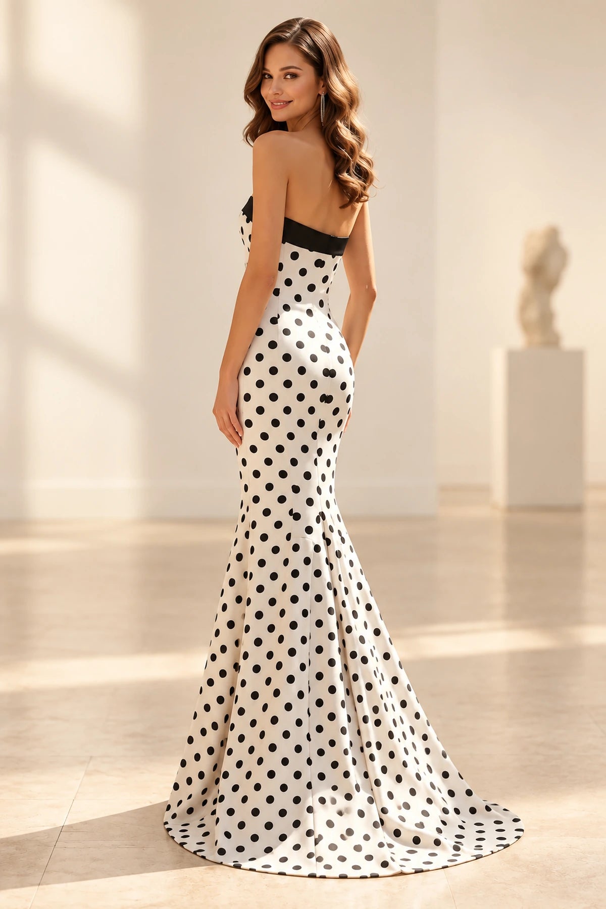 Back view of polka dot satin prom dress featuring straight strapless back, fitted mermaid silhouette and floor length sweep hem