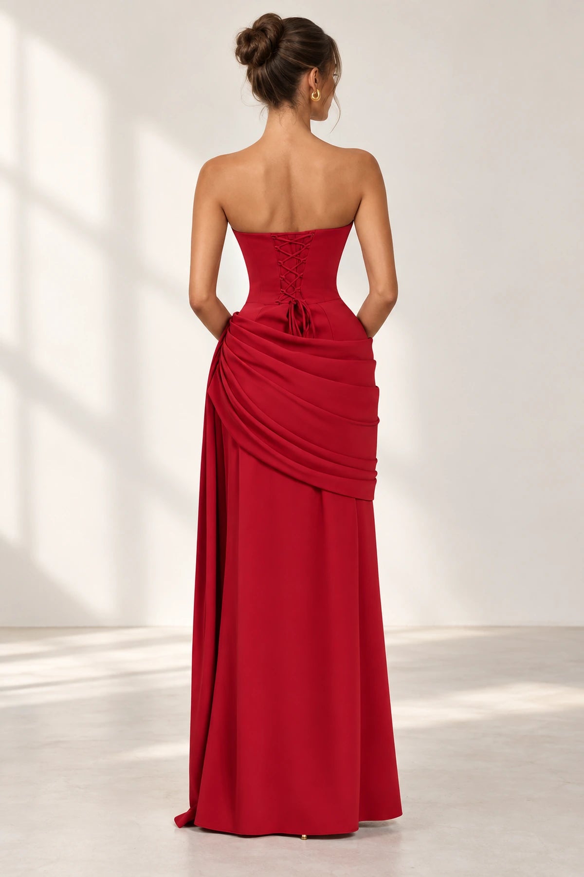 Red lace up back floor length wedding guest dress with draped skirt back view