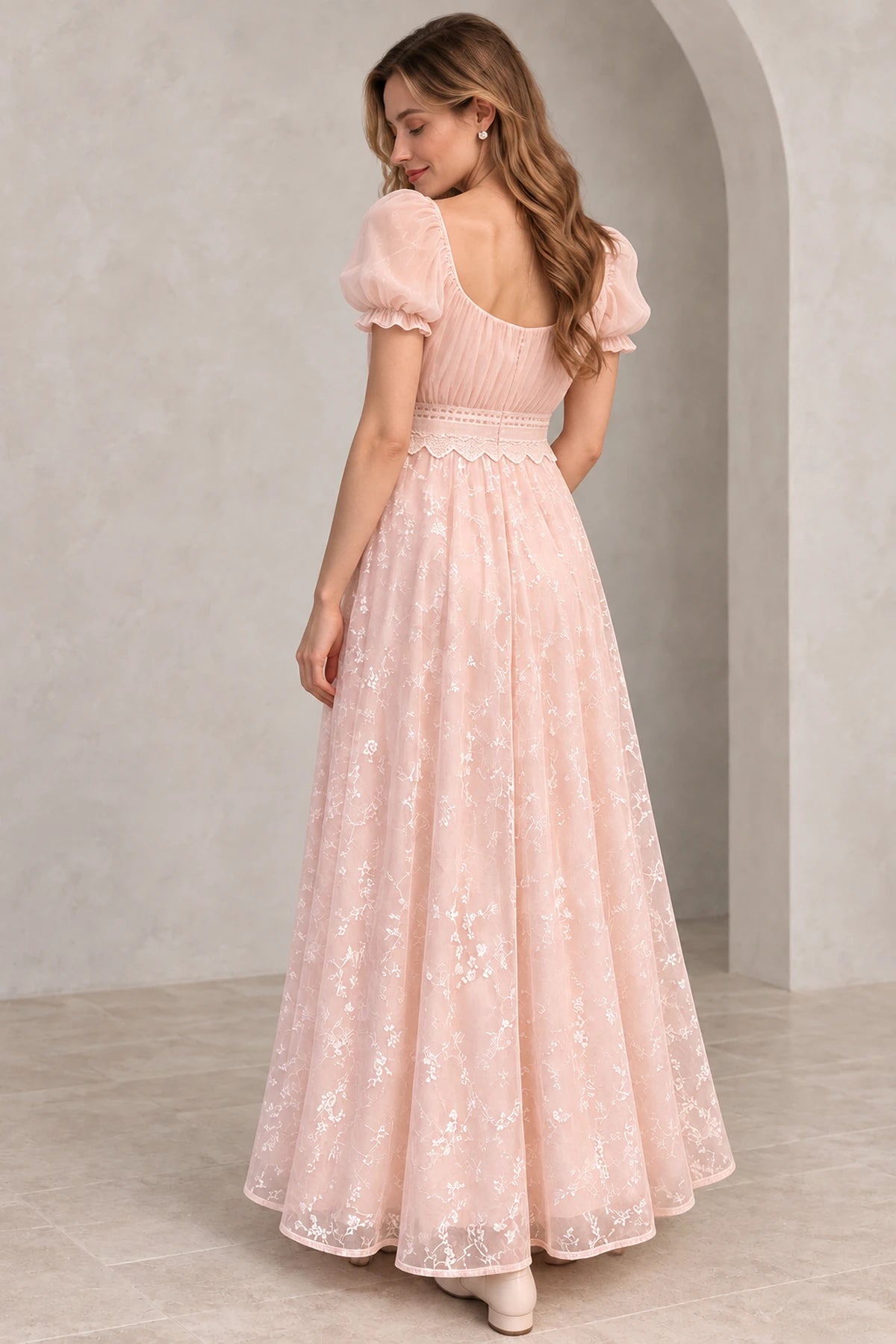 Blush pink floral tulle A-line wedding guest dress back view featuring puff sleeves, scoop back, lace waistband and flowing floor-length embroidered skirt