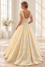 Butter yellow floral tulle prom dress back view featuring a scoop neckline, lace ruffle sleeves, embroidered corset, center zipper and voluminous ball gown skirt