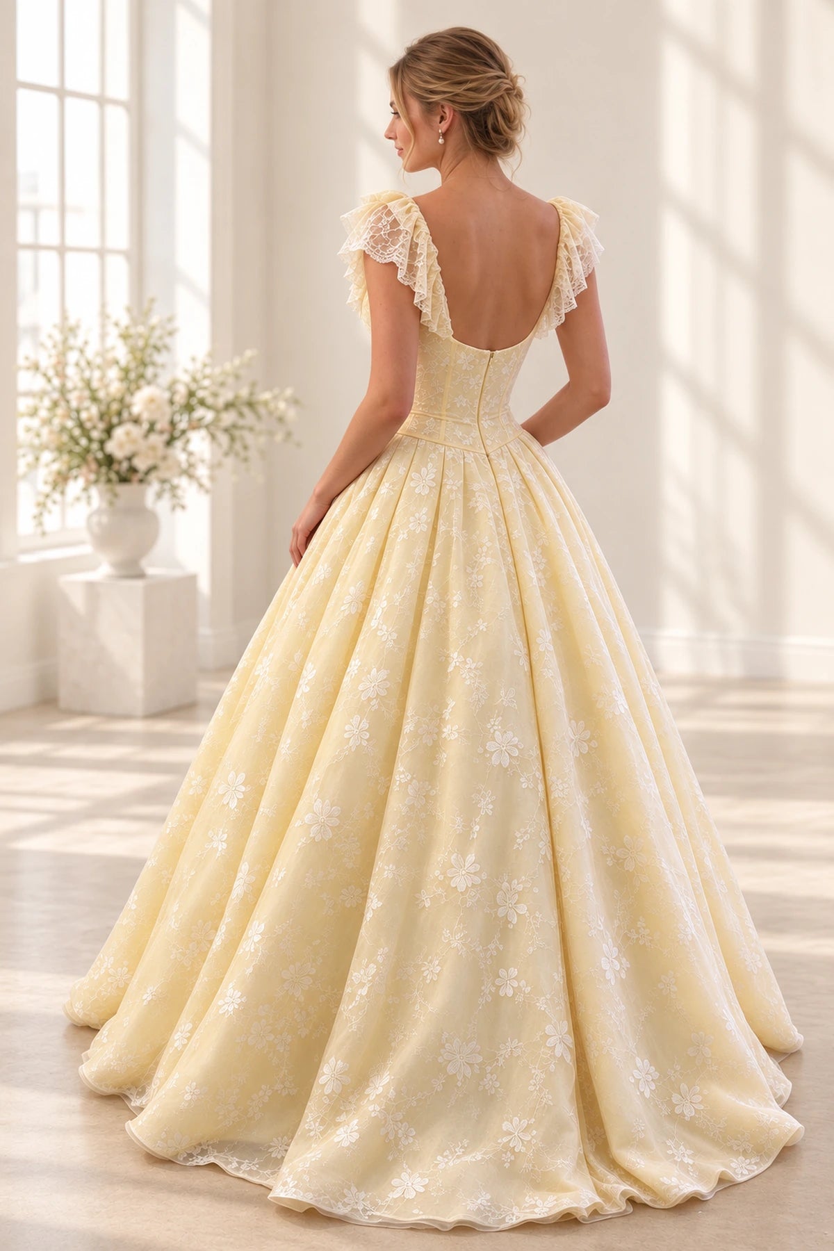 Butter yellow floral tulle prom dress back view featuring a scoop neckline, lace ruffle sleeves, embroidered corset, center zipper and voluminous ball gown skirt
