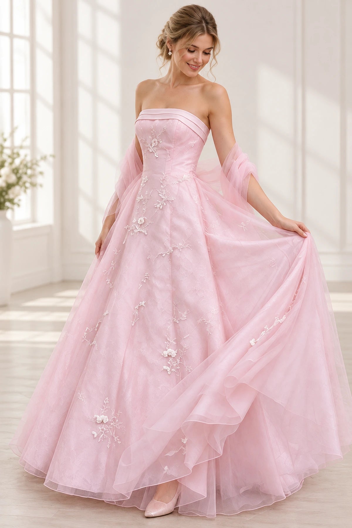 Blush pink tulle prom dress back view showing a strapless fitted bodice, center zipper, draped off-shoulder tulle wrap and floral embroidered A-line skirt