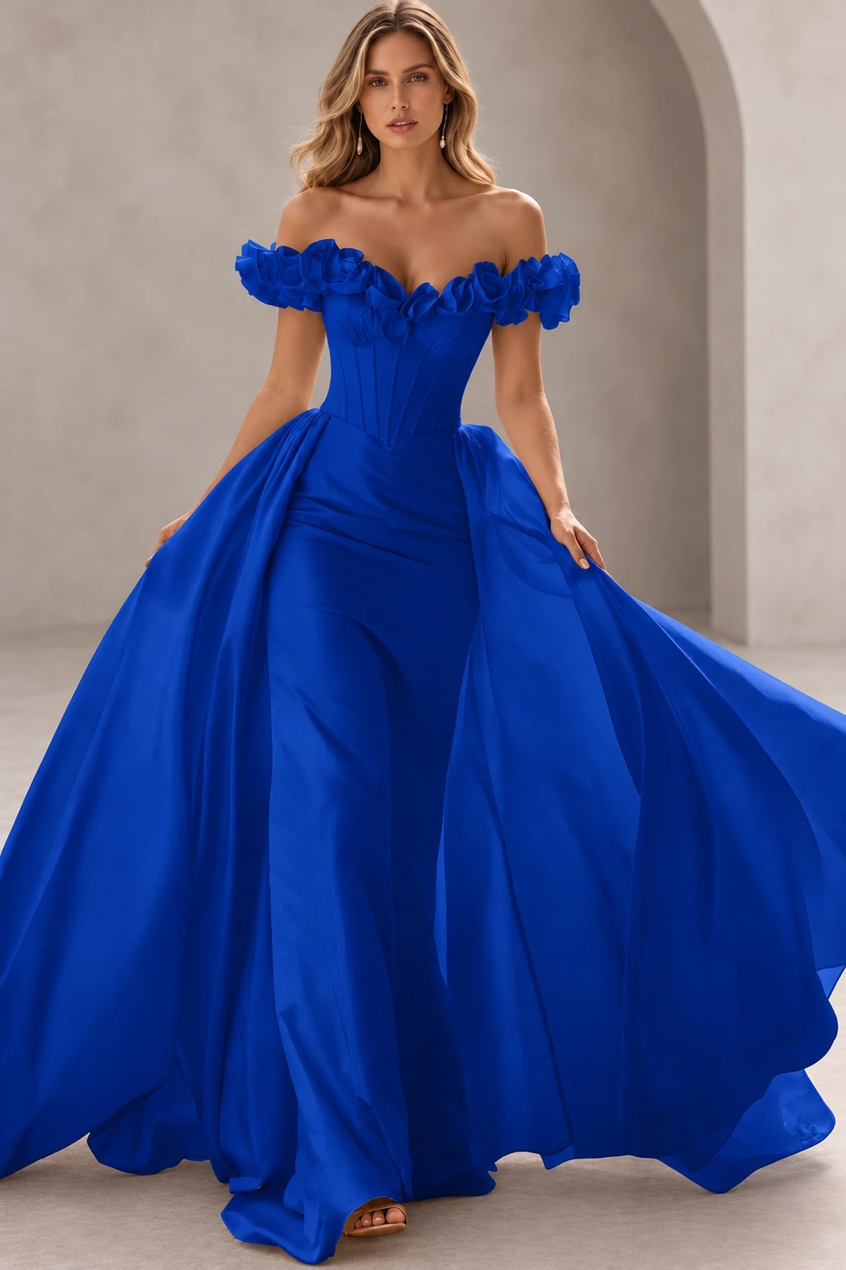 Royal blue prom dress with floral off-shoulder sleeves, sweetheart neckline, pointed corset-style bodice, pleated hips, and flowing outer skirt panels.
