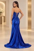 Royal blue prom dress with an exposed crisscross lace-up back, waist bow, center-back gathers, sparkling details, and sweeping train.