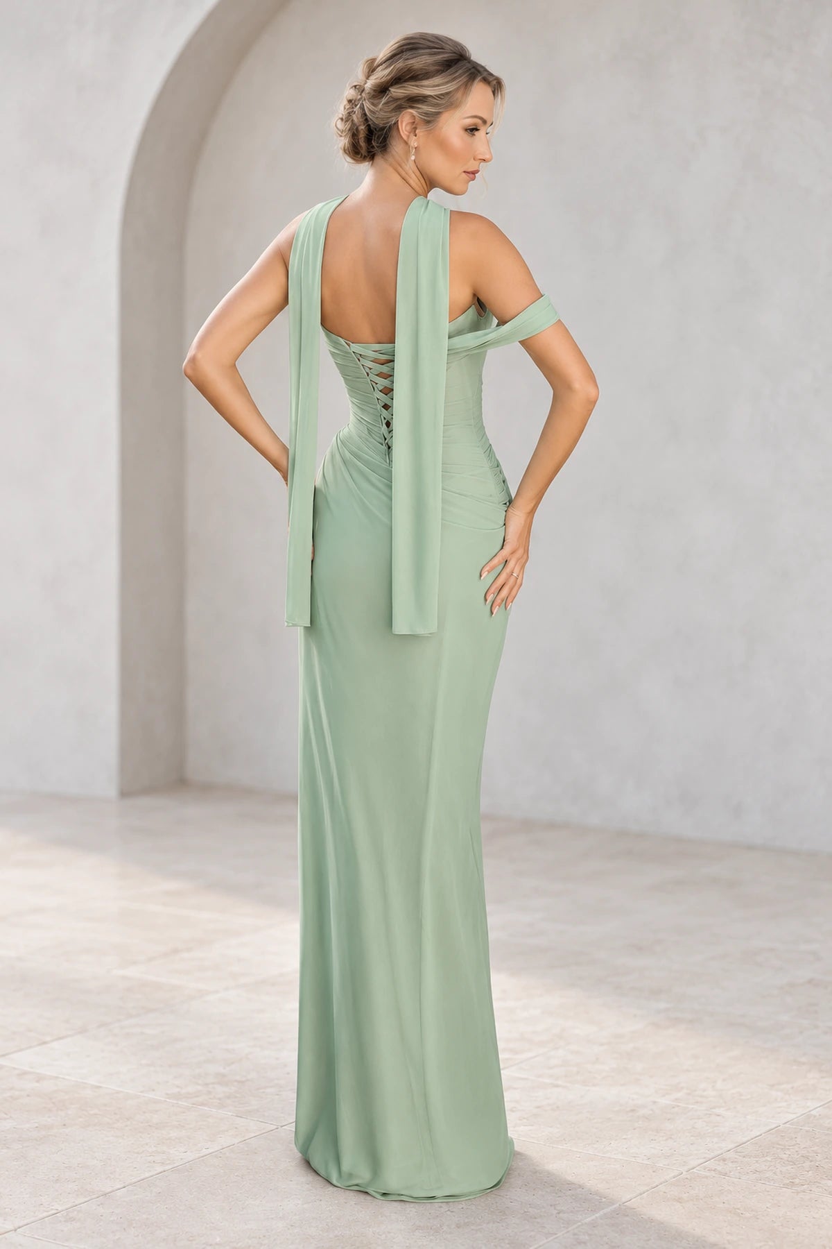 Back of Graceprom sage green chiffon gown with an open upper back, crisscross corset lacing and a matching scarf draped down the back.