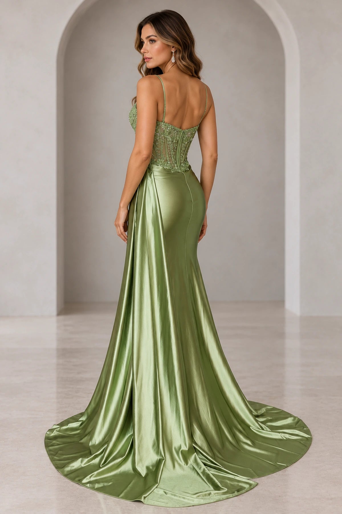 Back view of sage green mermaid prom dress featuring a sheer embellished corset back, delicate spaghetti straps, fitted satin skirt, and sweeping train.
