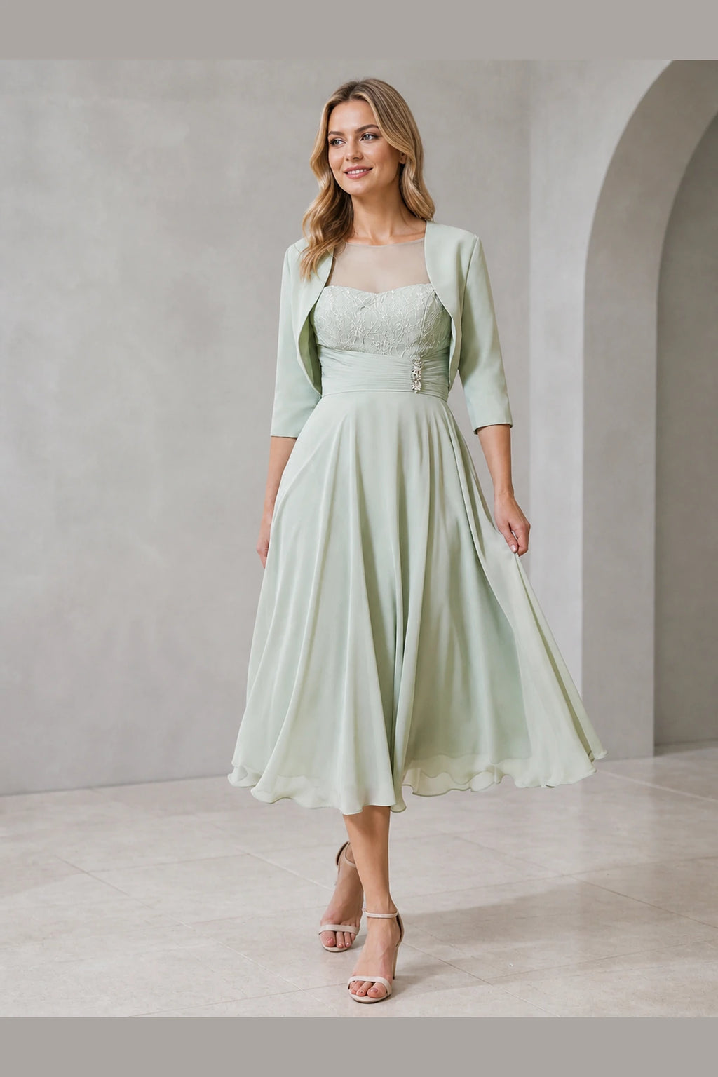 Vedress sage green mother of the bride dress with illusion neckline lace bodice bolero jacket ruched waist and midi A-line skirt front view