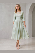 Vedress sage green mother of the bride dress with illusion neckline lace bodice bolero jacket ruched waist and midi A-line skirt front view