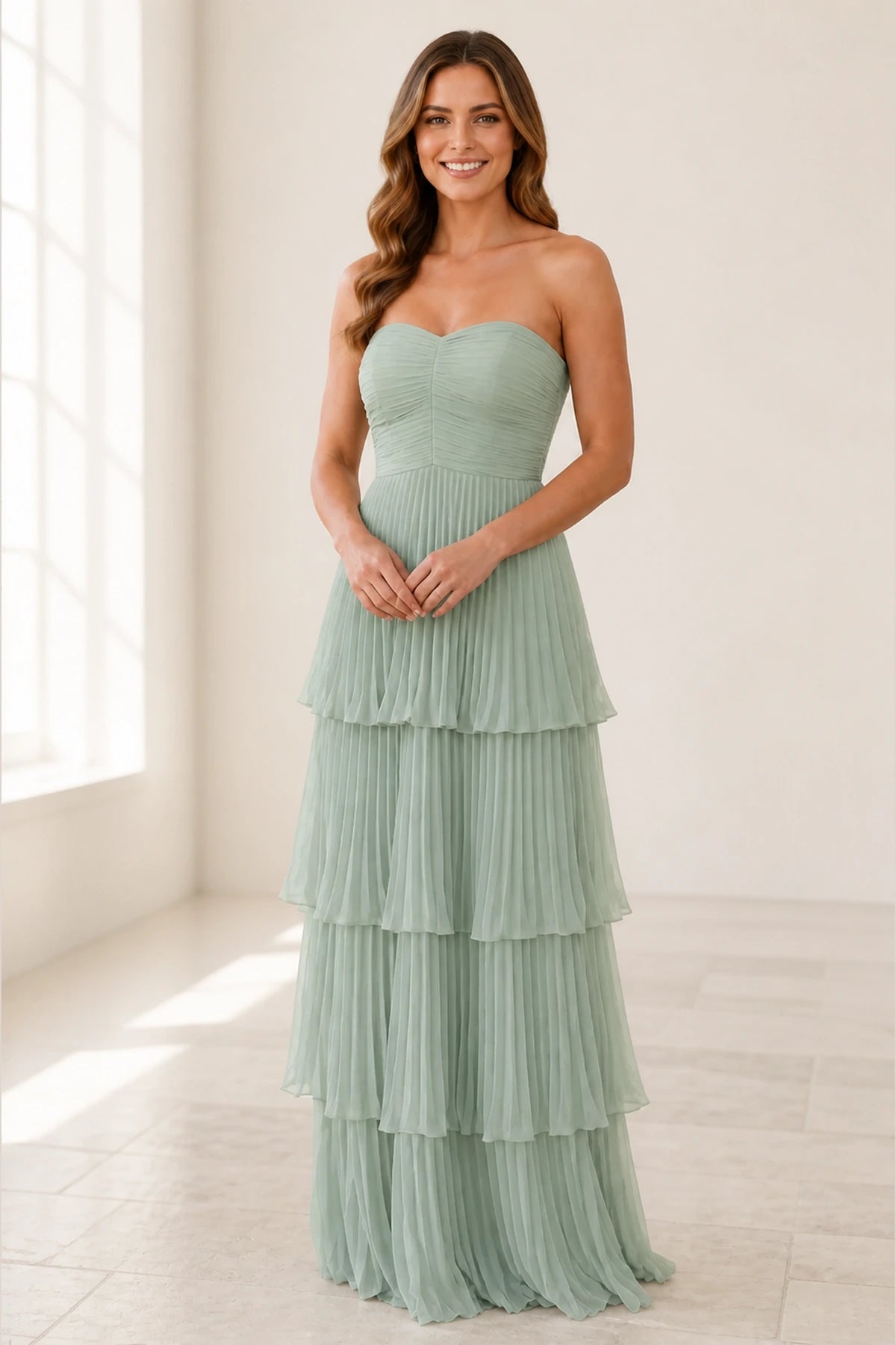 Sage green strapless bridesmaid dress with sweetheart neckline, ruched bodice and pleated tiered floor-length skirt