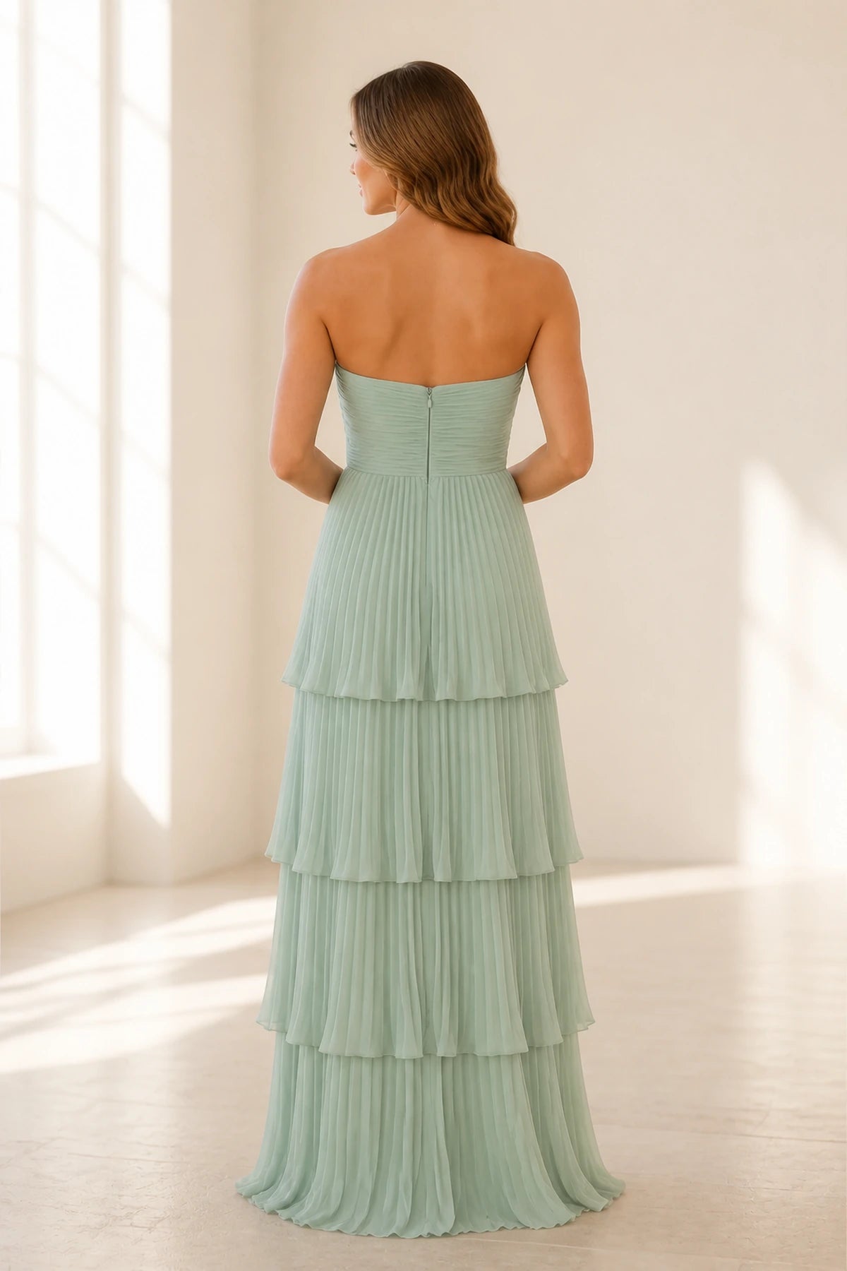 Back view of sage green bridesmaid dress with strapless zip back and pleated tiered A-line skirt