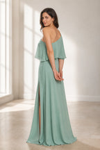Sage green floor-length wedding guest dress with asymmetric one-shoulder back and flowing ruffle overlay back view
