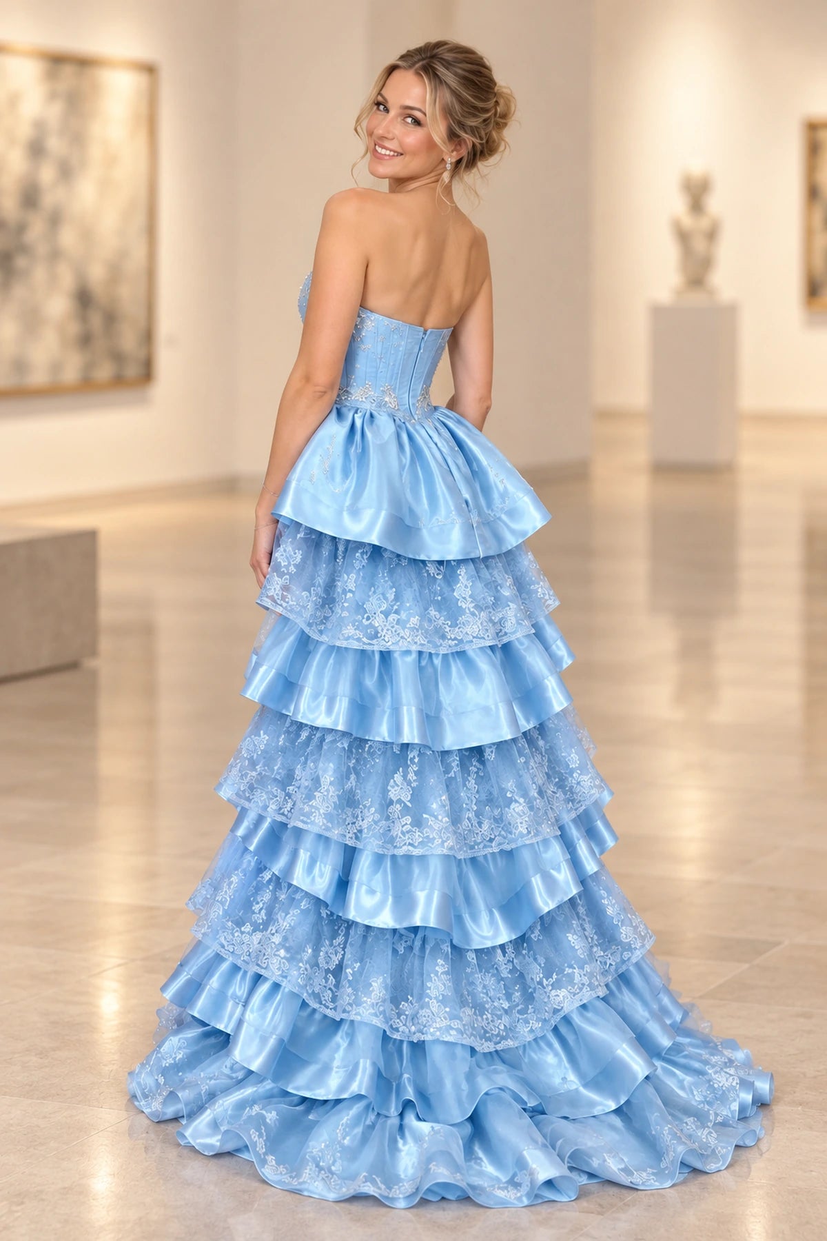 Back view of Graceprom light blue prom dress with a zipper back bodice, alternating satin and floral lace ruffles and a sweeping train.