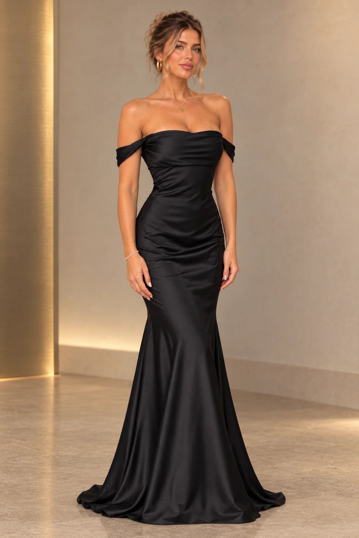 Black satin mermaid prom dress with off shoulder neckline, ruched fitted bodice, defined waist and flowing floor length flared skirt by Graceprom