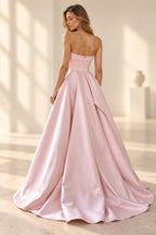 Back view of blush pink satin A-line prom dress featuring straight strapless back, center zipper, fitted waist and full pleated floor-length skirt