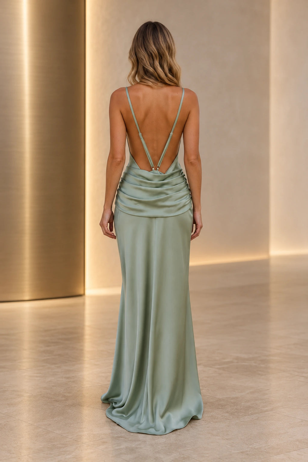 Back view of a sage green Graceprom satin bridesmaid dress with adjustable thin straps, a deeply open back and draped cowl folds at the waist.