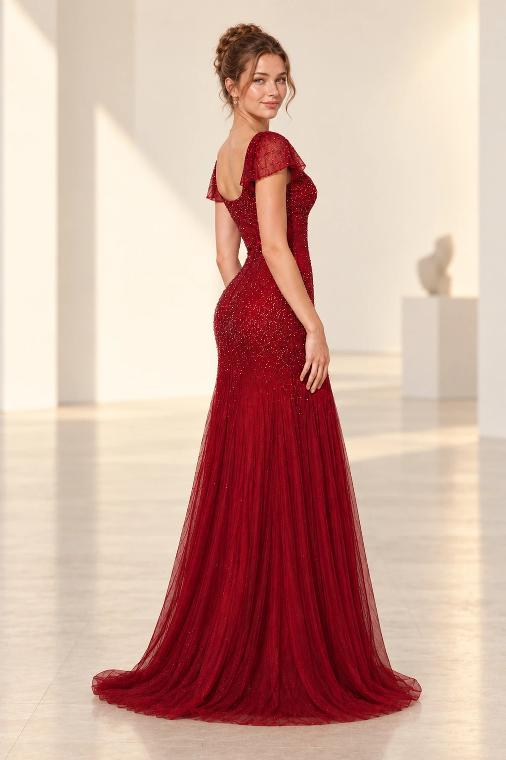 Back view of a burgundy Graceprom sequin wedding guest dress featuring a deep scoop back, center zipper, fitted hips and a sweeping train.
