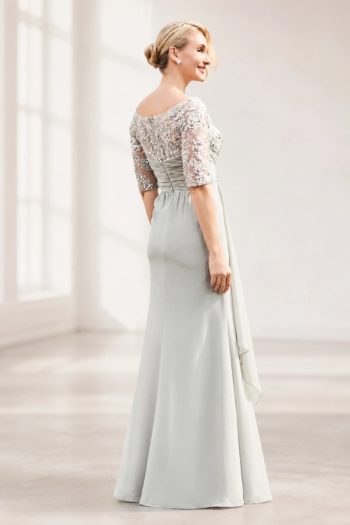 Silver gray mother of the bride dress with floral lace bodice, sheer half sleeves, ruched waist and layered floor-length skirt, front and back view