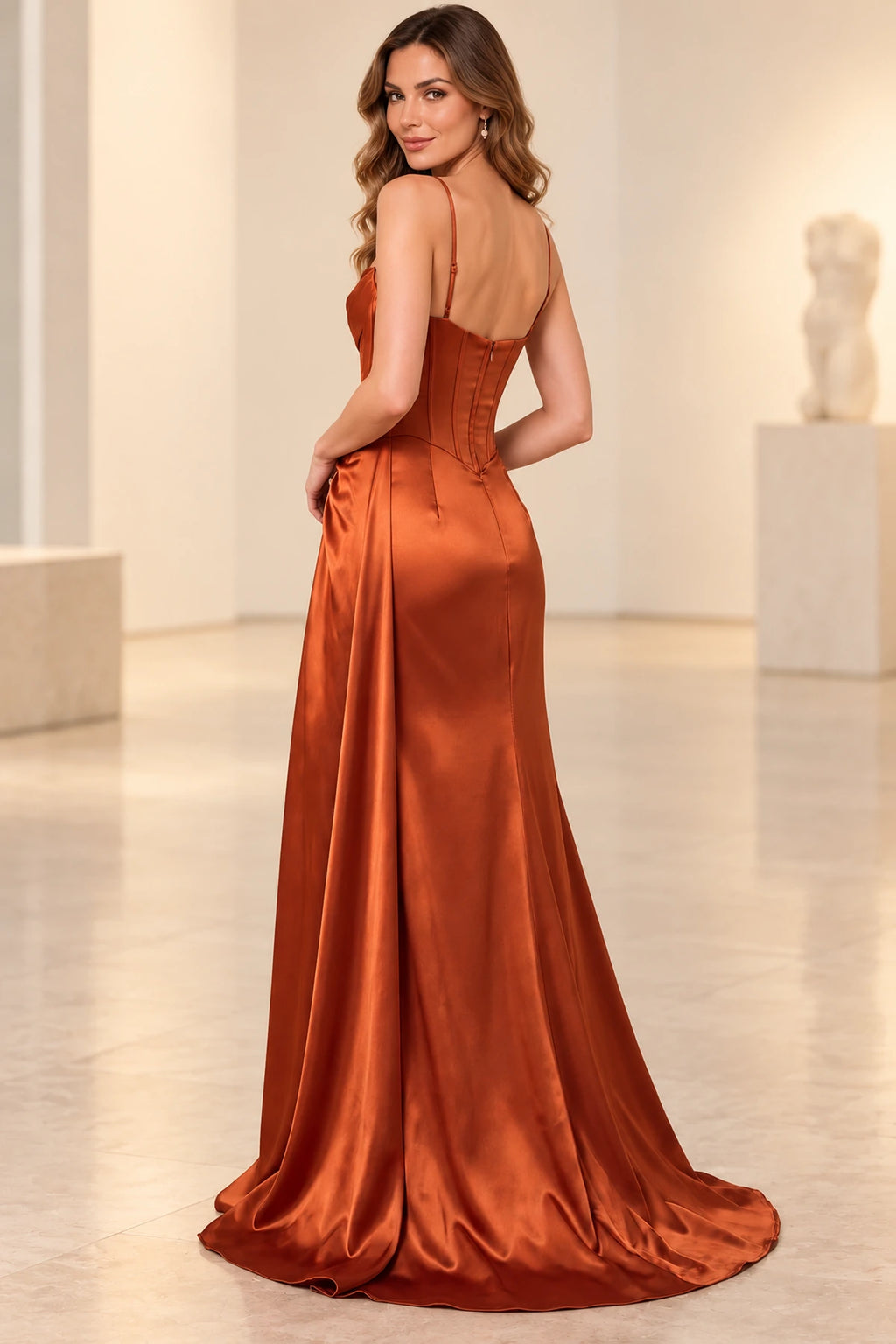 Back view of a rust satin prom dress with adjustable spaghetti straps, a low curved neckline, fitted zipper back, and slight train.