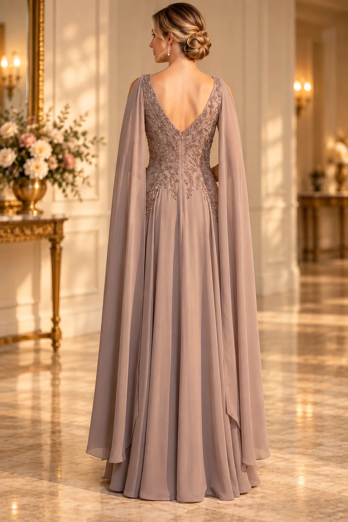 Back view of taupe Mother of the Bride Dress with deep V-back, embellished bodice, flowing cape panels and floor-length A-line skirt