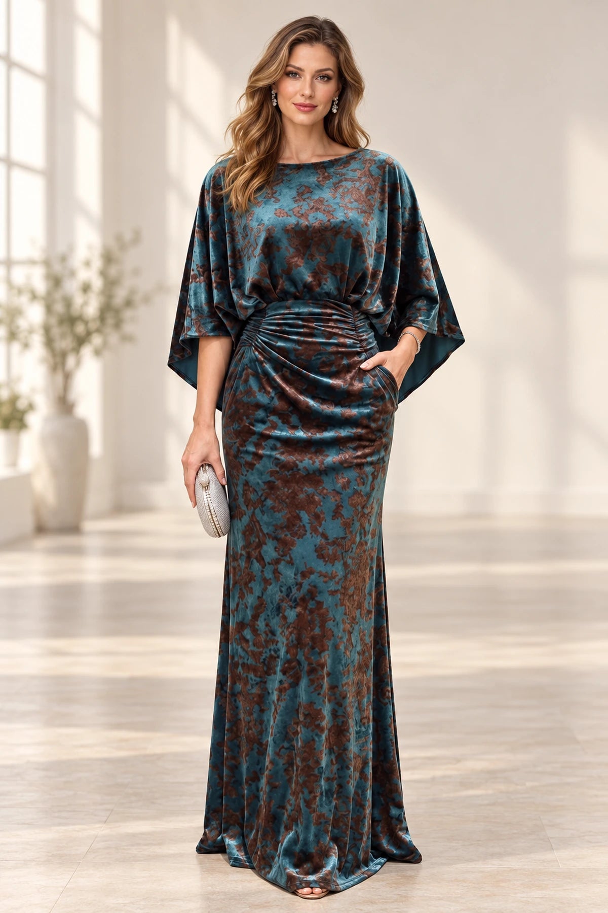 Teal and brown floral mother of the bride dress with bateau neckline cape sleeves ruched waist and floor-length sheath silhouette
