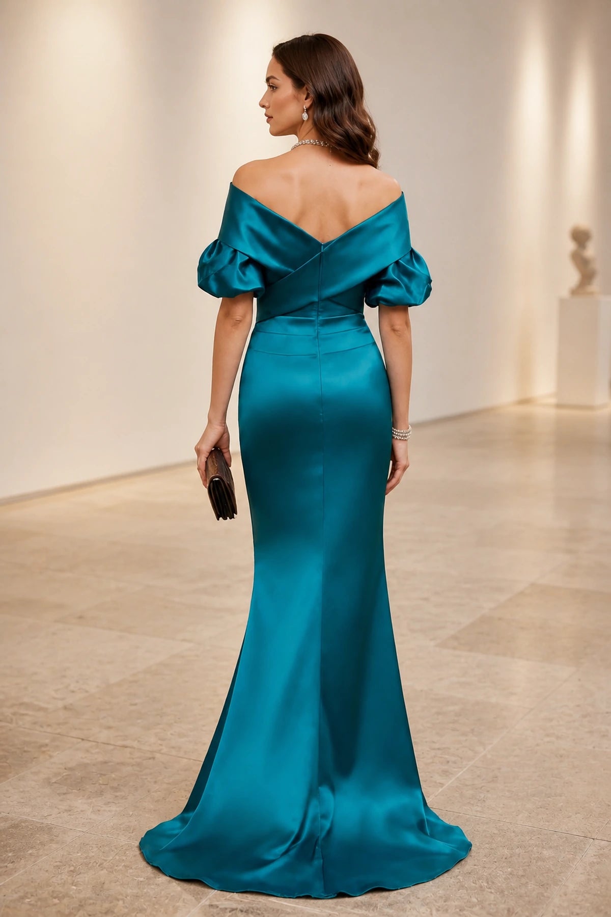 Back view of teal satin evening dress with off-shoulder V-back, puff sleeves and mermaid floor-length skirt