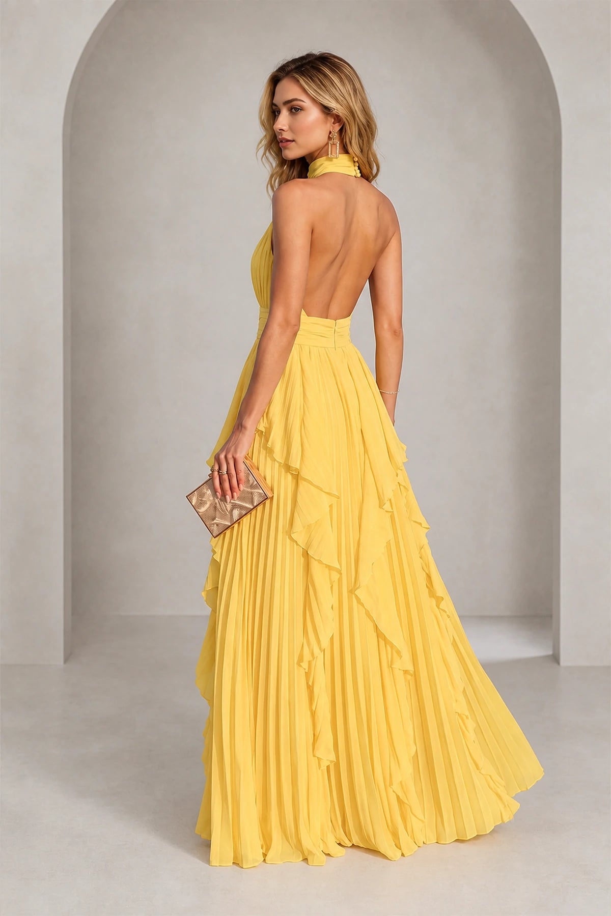 Yellow halter neck bridesmaid dress with open back and pleated ruffle skirt